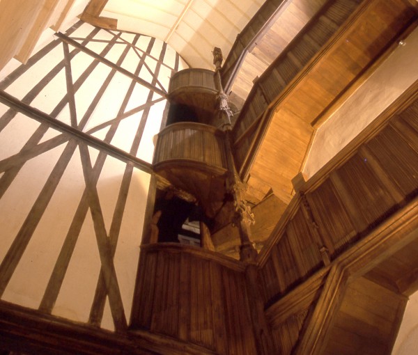 Ce cliché réalisé par le photographe RV Ronné est une vue en contre plongée de l'escalier dans la Maison à Pondalez du 9 Grand'Rue à Morlaix. Au centre de cette photo, un escalier à vis monte sur trois étages. Sur la partie droite, à chaque niveau, un balcon avec une main courante joliment sculptée dans un style gothique flamboyant. De l'autre coté de l’image, à gauche de l'escalier un grand mur intérieur montre le joli dessin des pans de bois coupés par une croix de st André. Ces éléments architecturaux montent jusqu'au toit que l'on voit dans la partie supérieure de l'image.